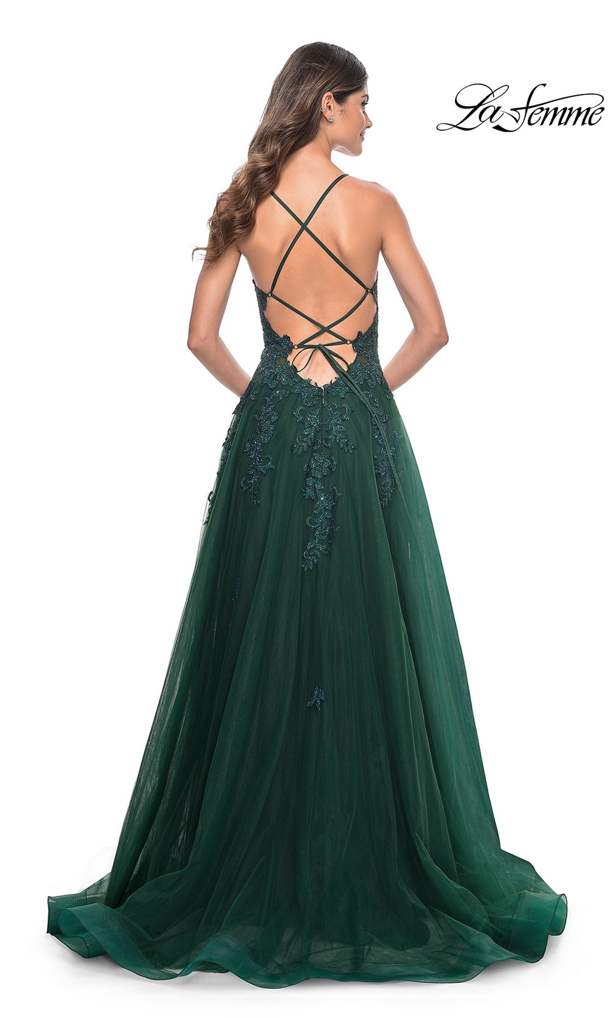 A woman shown from behind wears the La Femme Embroidered-Lace Long Prom Gown 32022, a floor-length dark green dress with floral lace accents and an open back with crisscross straps.